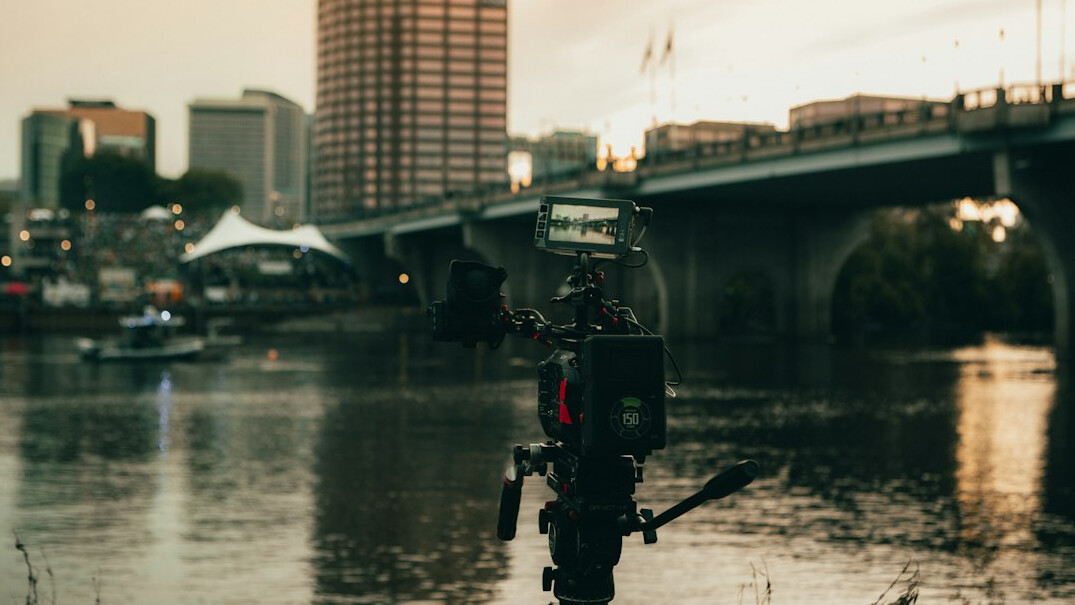 Shoulder mounted news camera on a tripod outdoors in the city